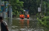 Dùng thuyền tiếp tế thực phẩm cho người dân bị cô lập do mưa bão gây ngập úng ở giáo xứ Đồng Chiêm