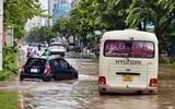 Người dân đi làm trong mưa ngập ở Hà Nội
