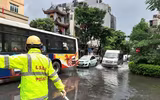 Cảnh sát giao thông dầm mình trong mưa lớn, đường ngập để phân luồng chống ùn tắc