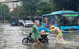 CSGT dầm mưa dùng xe cẩu đưa người dân qua đoạn đường ngập sâu