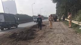 Cảnh sát giao thông Hà Nội quét dọn đất cát rơi trên Đại lộ Thăng Long