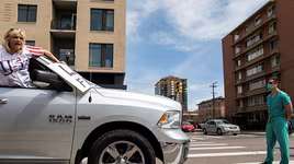 [ẢNH] Nhân viên y tế Mỹ đứng chặn đầu đoàn xe biểu tình đòi dỡ phong tỏa