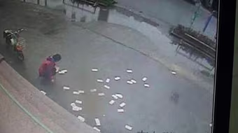 Người dân nhặt giúp tiền bị gió thổi bay tứ tán