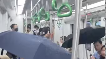 Người dân che ô trên tàu metro Cát Linh- Hà Đông vì nước chảy tong tong