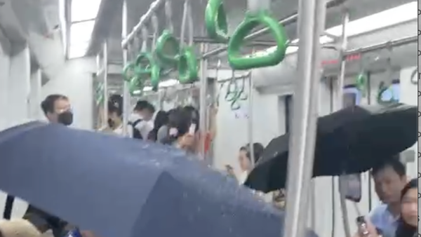 Người dân che ô trên tàu metro Cát Linh- Hà Đông vì nước chảy tong tong
