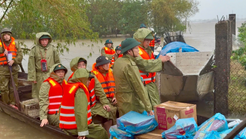 Chèo xuồng đưa cơm đến cho người dân mắc kẹt trong mưa ngập tại thành phố Huế
