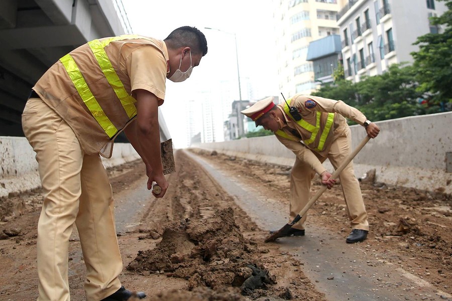 Cảnh sát giao thông Hà Nội nỗ lực dọn bùn đất đảm bảo ATGT