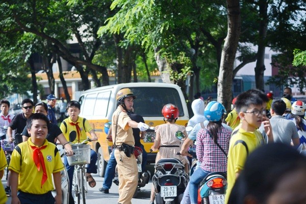 Lực lượng CSGT phân luồng đảm bảo ATGT cho dòng người đưa đón con đến trường dự lễ khai giảng ở tuyến đường Trần Huy Liệu