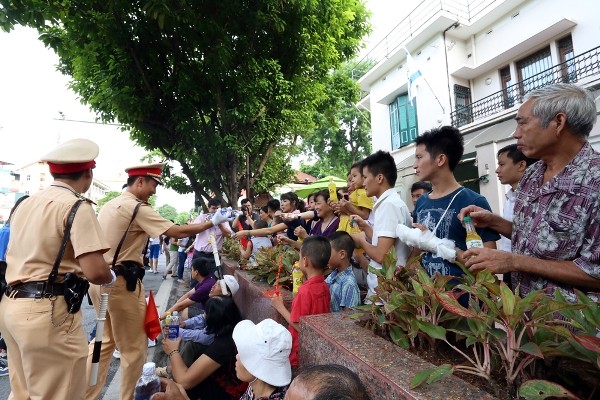 Cảnh sát giao thông biếu nước cho người dân xem diễu binh, diễu hành ảnh 3