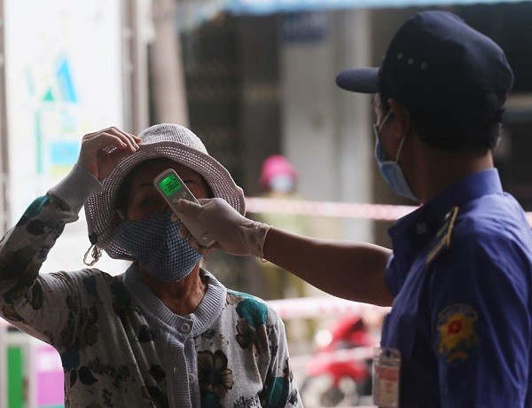 Lực lượng bảo vệ cũng kiêm luôn nhiệm vụ đo nhiệt độ từng người dân đến chợ