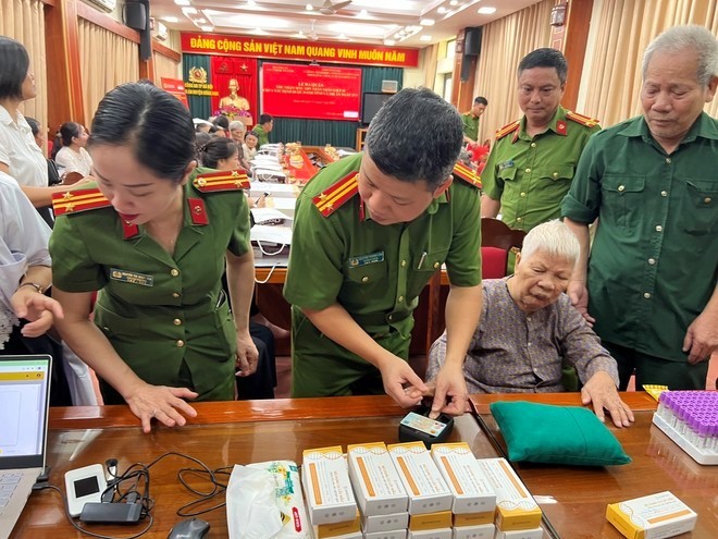 Chỉ huy Phòng Cảnh sát QLHC về TTXH - CATP Hà Nội thu nhận mẫu ADN cho thân nhân liệt sỹ chưa xác định danh tính trên địa bàn huyện Đông Anh