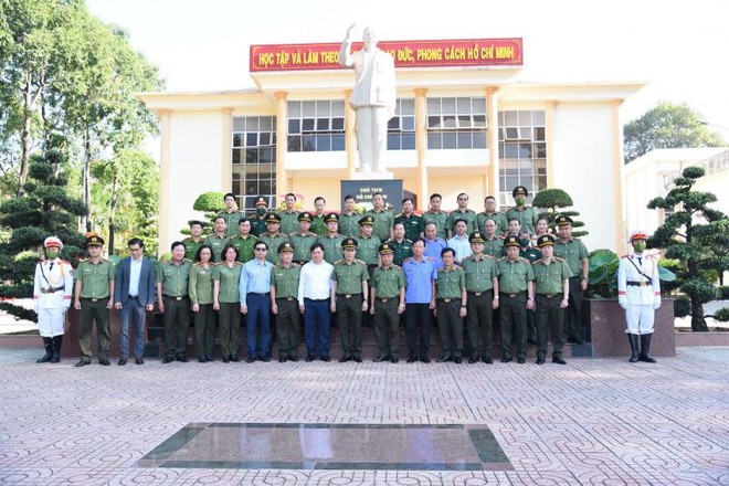 Các đại biểu tham dự hội thảo chụp hình lưu niệm tại khu Tượng đài Chủ tịch Hồ Chí Minh trong khuôn viên Đại học ANND.