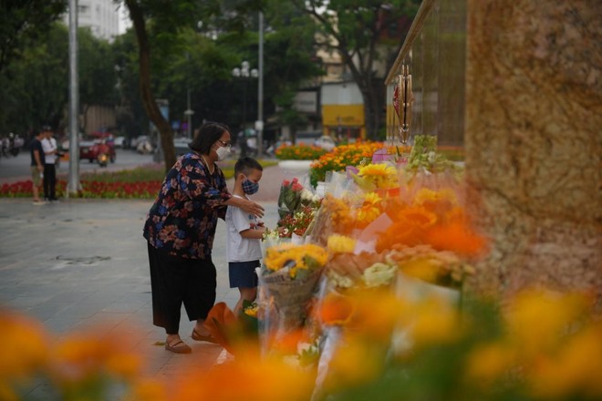 Một em nhỏ được bà dẫn đến dâng hoa trước tượng đài các chiến sĩ Công an Một em nhỏ được bà dẫn đến dâng hoa trước tượng đài các chiến sĩ Công an