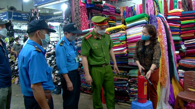 Trung úy Nguyễn Như Đại đang kiểm tra kỹ năng sử dụng bình bọt chữa cháy của các tiểu thương tại chợ Mơ