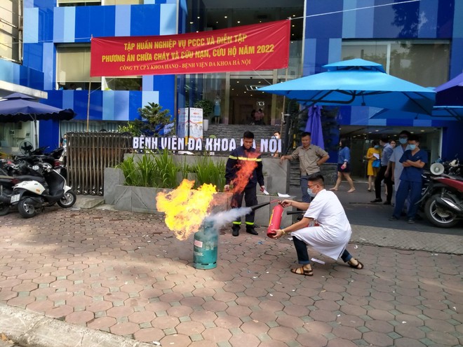 Cán bộ, nhân viên Bệnh viện đa khoa Hà Nội đang thực hành chữa cháy bằng bình chữa cháy mini.