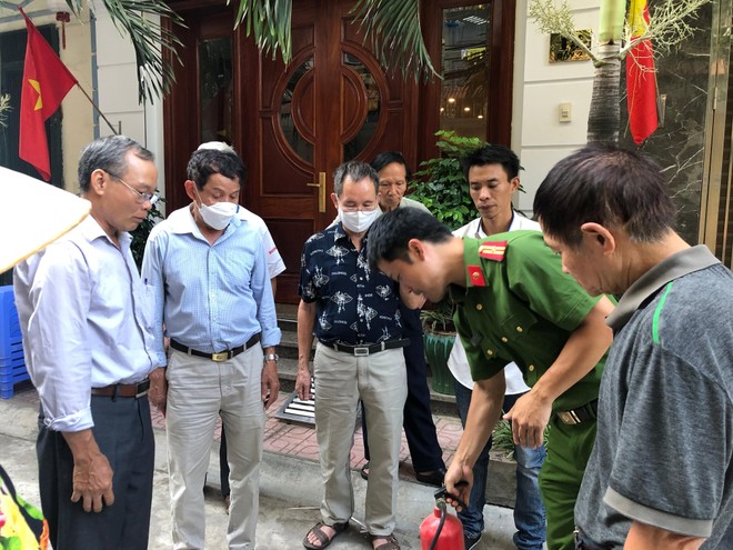 Cán bộ Đội Cảnh sát PCCC và CNCH - Công an quận Hai Bà Trưng hướng dẫn cách sử dụng bình chữa cháy cầm tay cho người dân trong tổ liên gia trong ngày ra mắt.