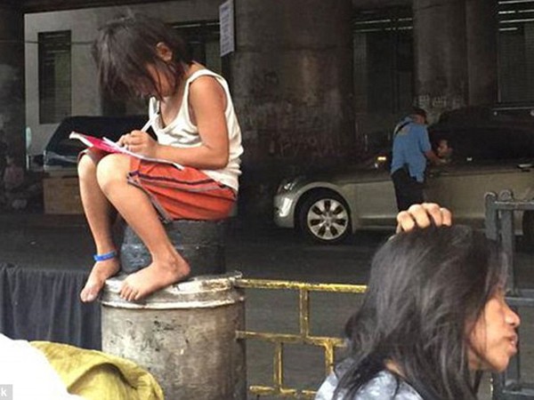 Bé gái mải mê học tập cạnh con đường đông đúc ảnh 1 Bé gái mải mê học tập cạnh con đường đông đúc ảnh 1