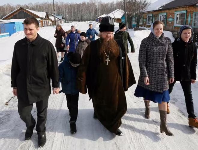 Linh mục Sergei Ryzhov (giữa) và các thành viên gia đình đi bộ tới điểm bỏ phiếu ở ngôi làng thuộc vùng Siberia