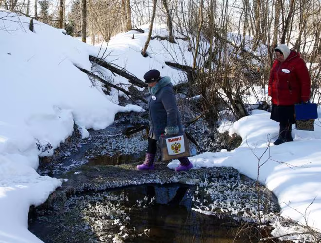 Thành viên của ủy ban bầu cử mang hòm phiếu di động tới phục vụ những cử tri không thể tới điểm bỏ phiếu, ở Vùng Smolensk