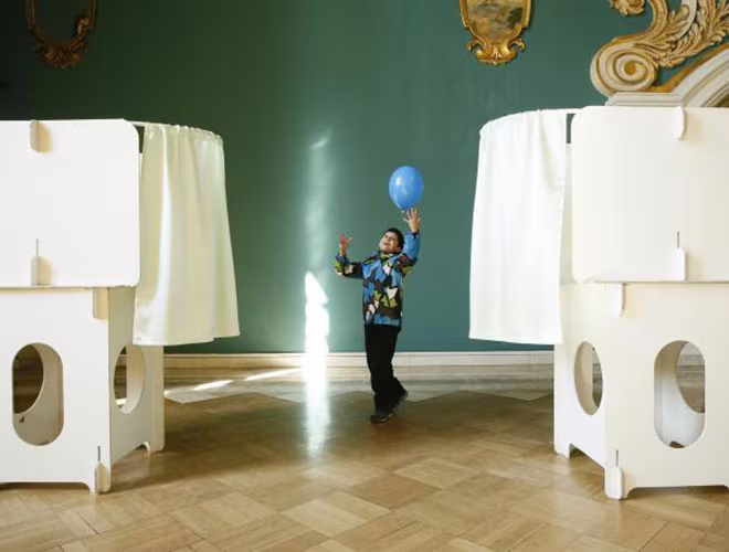 Em bé chơi đùa với trái bóng gần điểm bỏ phiếu ở thủ đô Moscow