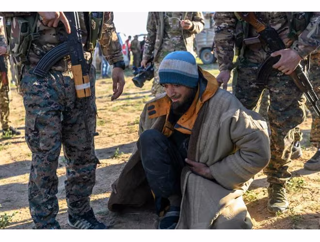 Binh sĩ SDF kiểm tra tay súng IS trước khi tiến hành di tản Binh sĩ SDF kiểm tra tay súng IS trước khi tiến hành di tản