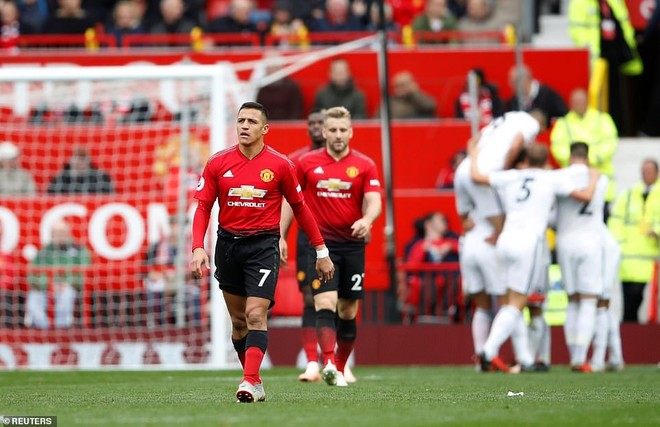 Manchester United look dejected as they walk back to the halfway line with Wolves players celebrating in the background