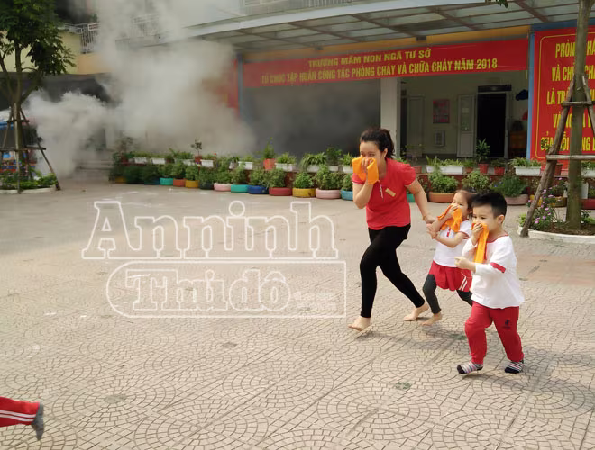 Một số em khác được giáo viên đưa ra nơi an toàn. Các em được trang bị khăn mặt ướt để chống khói độc. Một số em khác được giáo viên đưa ra nơi an toàn. Các em được trang bị khăn mặt ướt để chống khói độc.