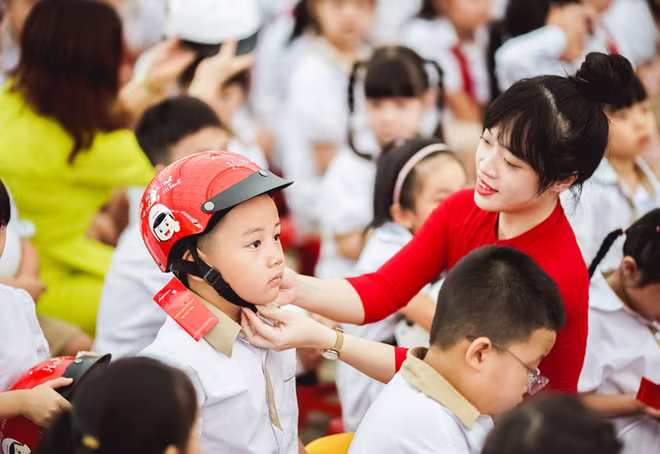Giáo viên hướng dẫn các em đội mũ bảo hiểm đúng cách Giáo viên hướng dẫn các em đội mũ bảo hiểm đúng cách