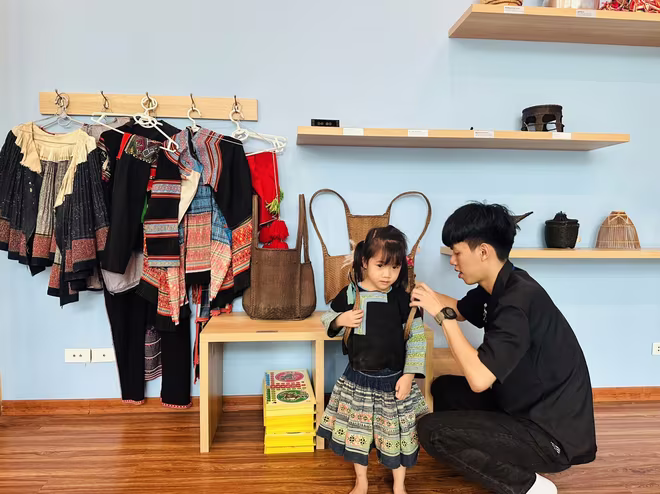 Em nhỏ thử mặc trang phục dân tộc Mông.