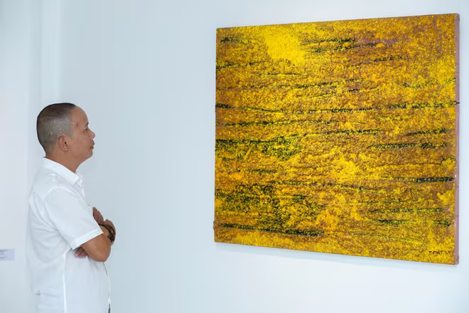 Họa sĩ Trần Vĩnh Thịnh bên tác phẩm