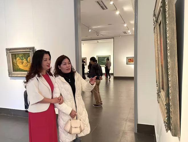 Người xem thưởng lãm tác phẩm tại triển lãm của cố họa sĩ Đồng Huy Biên.