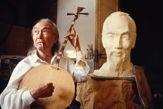 Nhà điêu khắc Diệp Minh Châu bên bức tượng chân dung Chủ tịch Hồ Chí Minh năm 1990.