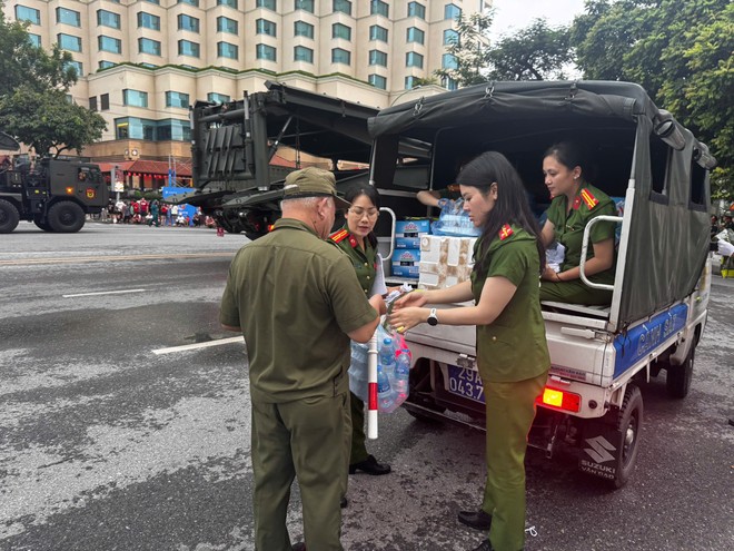 Tổ công tác Công an phường Tây Hồ mang nước suối đến các chốt làm nhiệm vụ bảo vệ sự kiện A80