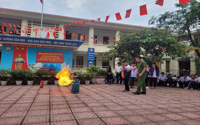 Các em học sinh tham gia phần thực hành dập tắt đám cháy giả định