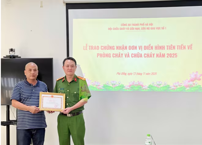 Trung tá Vũ Thế Đông - Đội trưởng Đội Chữa cháy và cứu nạn, cứu hộ Khu vực số 1 trao Chứng nhận đơn vị điển hình tiên tiến về Phòng cháy và chữa cháy cho lãnh đạo Công ty Cổ phần dầu khí An Pha