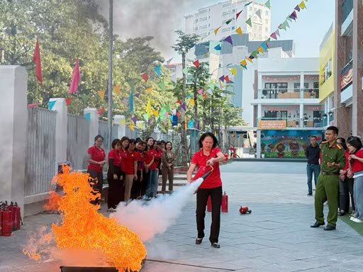 Các giáo viên, nhân viên được thực hành sử dụng bình chữa cháy tại chỗ Các giáo viên, nhân viên được thực hành sử dụng bình chữa cháy tại chỗ