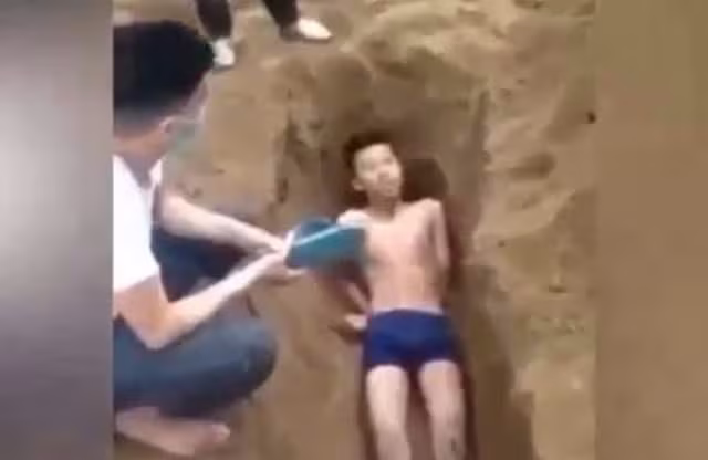 Hình ảnh nam thanh niên bị đẩy vào hố cát (ảnh cắt từ clip) Hình ảnh nam thanh niên bị đẩy vào hố cát (ảnh cắt từ clip)