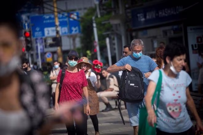 Người dân Israel đeo khẩu trang khi đi trên đường phố Tel Aviv hôm 22-7 Người dân Israel đeo khẩu trang khi đi trên đường phố Tel Aviv hôm 22-7