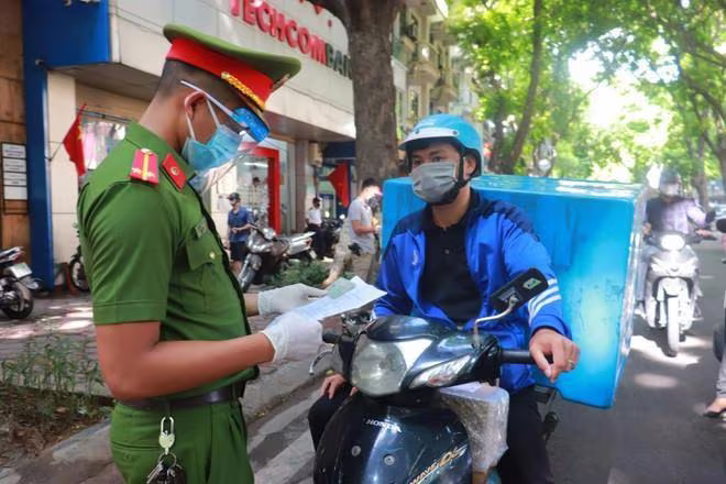 Lực lượng công an kiểm tra giấy đi đường của người dân Lực lượng công an kiểm tra giấy đi đường của người dân