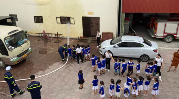 Giáo viên và các em học sinh trải nghiệm cách cầm lăng vòi và phun nước vào đám cháy. Giáo viên và các em học sinh trải nghiệm cách cầm lăng vòi và phun nước vào đám cháy.