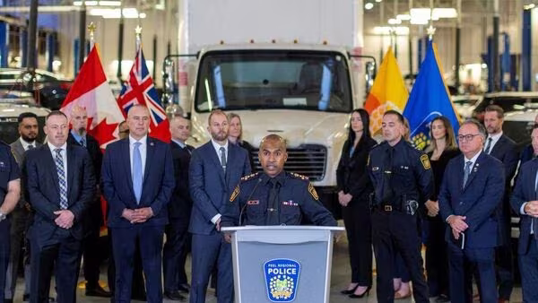 Ông Nishan Duraiappah - Cảnh sát trưởng khu vực Peel thông báo về việc khởi tố 9 đối tượng, phía sau là chiếc xe tải liên quan đến vụ trộm tiền vàng kỷ lục ở Canada