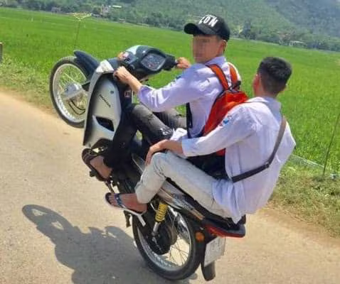 Hai nam thanh niên điều khiển xe máy bằng một bánh Hai nam thanh niên điều khiển xe máy bằng một bánh