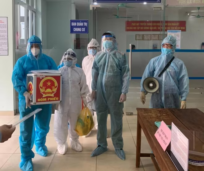 Lực lượng chức năng mang hòm phiếu đến nhà để cử tri đang cách ly thực hiện bỏ phiếu Lực lượng chức năng mang hòm phiếu đến nhà để cử tri đang cách ly thực hiện bỏ phiếu