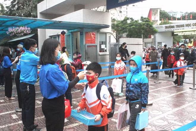 Các thầy, cô phụ trách đoàn, đội đo thân nhiệt, rửa tay diệt khuẩn cho học sinh khi đến trường