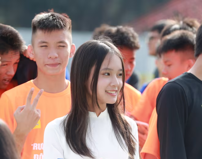 Nụ cười tươi như nắng thu của nữ sinh cầm biển trường trong lễ khai mạc giải. Sự trong trẻo, tự tin và duyên dáng của cô gái khiến không khí ngày hội bóng đá thêm phần rộn ràng và đáng nhớ