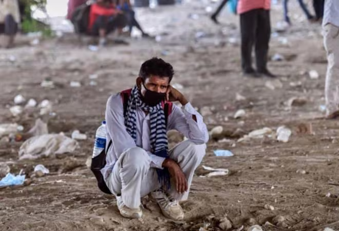 Người lao động vạ vật trên đường phố ở New Delhi chờ được phân phát thực phẩm Ảnh: Business Today