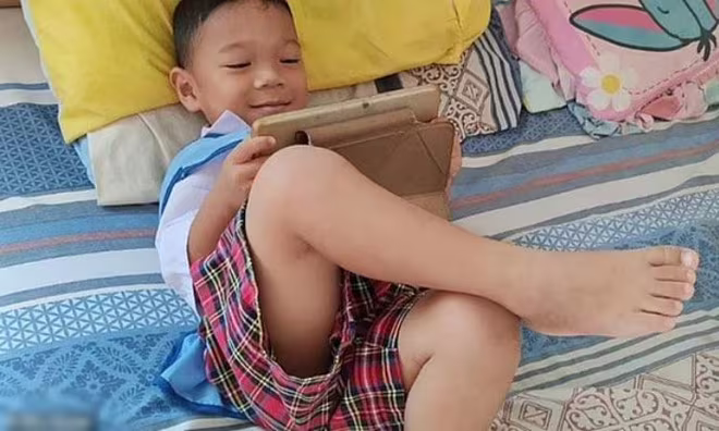 Bé Sumaee sử dụng máy tính bảng trước khi bị tấn công ở nhà trẻ ở Thái Lan. Ảnh: Sky News. Bé Sumaee sử dụng máy tính bảng trước khi bị tấn công ở nhà trẻ ở Thái Lan. Ảnh: Sky News.