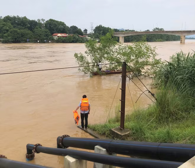 Người đàn ông may mắn bám được vào cây giữa dòng nước lũ và được cứu sau đó