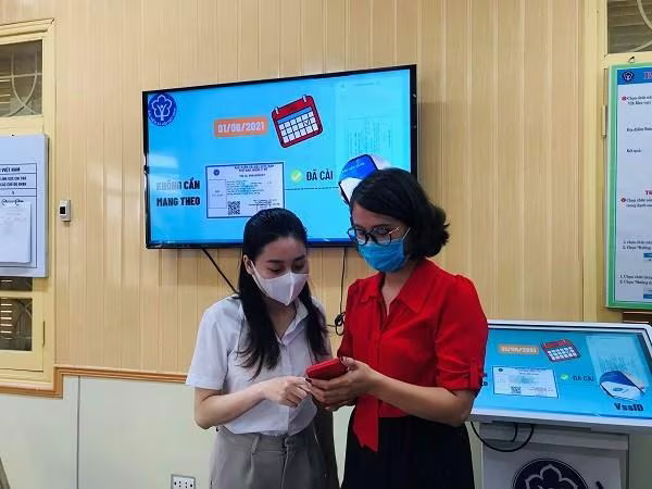 Cán bộ bảo hiểm xã hội hướng dẫn người lao động cài đặt ứng dụng VssID Cán bộ bảo hiểm xã hội hướng dẫn người lao động cài đặt ứng dụng VssID