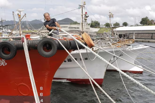 Ngư dân chằng buộc thuyền để tránh bão ở Makurazak Ngư dân chằng buộc thuyền để tránh bão ở Makurazak